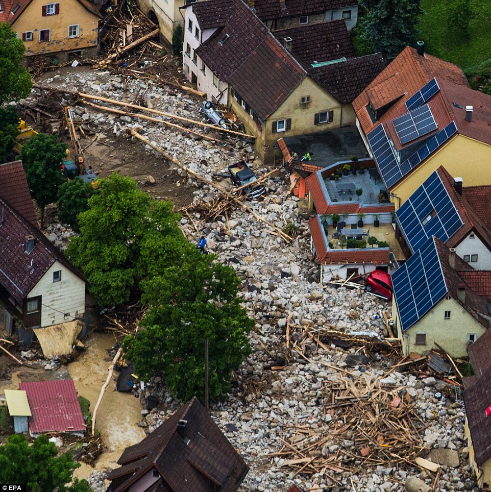 Trail of destruction: Debris and rubble can be seen piled up in a residential street after heavy storms hit the German town of Braunsbach